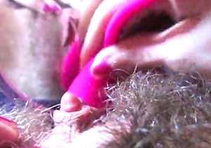 Extra-hairy mature cunt pleasured by a pink toy